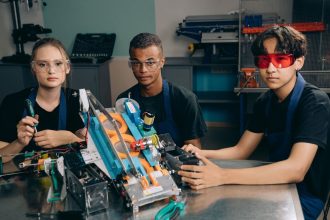 Estudantes trabalham juntos em um projeto de robótica em um laboratório de tecnologia.