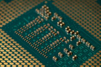 Close-up de um microprocessador e dos circuitos eletrônicos de uma placa, com componentes densamente interligados.