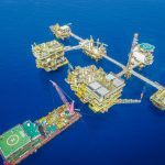 Vista aérea de uma plataforma offshore de petróleo e gás em alto-mar.