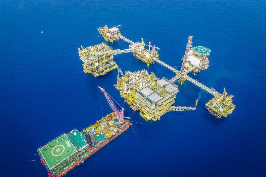 Vista aérea de uma plataforma offshore de petróleo e gás em alto-mar.