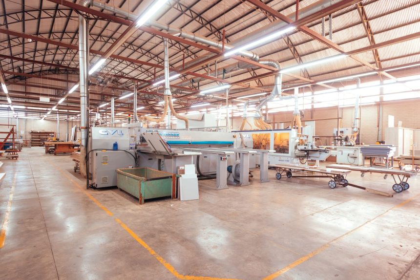 Vista ampla de uma fábrica brasileira organizada, com máquinas industriais em uma linha de produção.